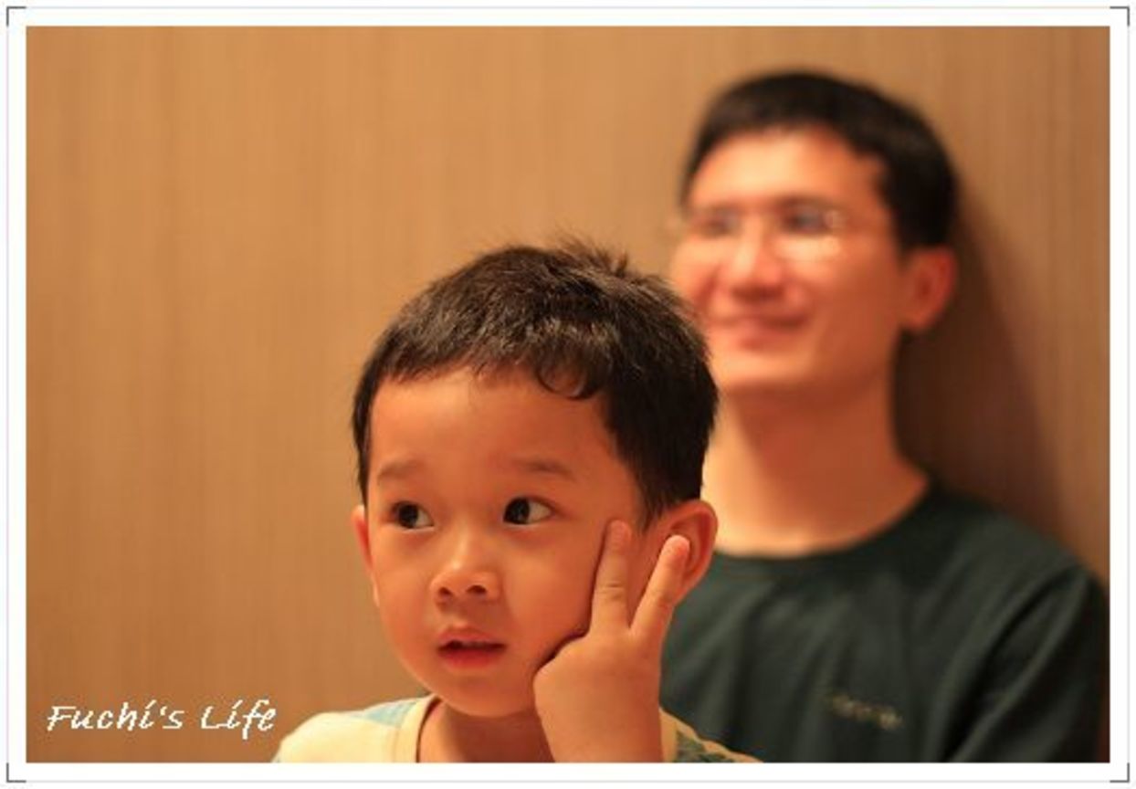 背後是看電視出神的爸爸