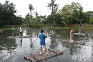 在大型水管製作的膠筏上划槳迎風搖曳