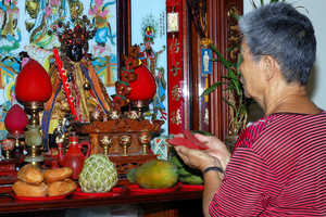 在神龕前求神問卜的信眾